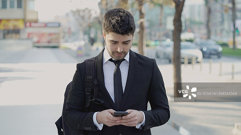 年轻商人在街上发短信图片素材