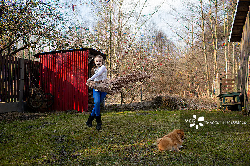在乡村房屋后院编着辫子，欢快地迎接春天的女孩图片素材