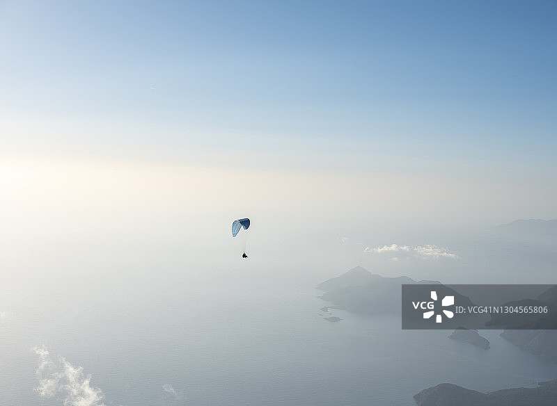 在厄吕代尼兹巴巴达格山上空飞行的滑翔伞图片素材