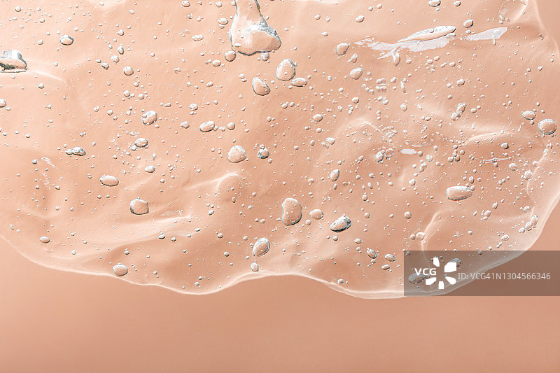 米色背景上的透明保湿精华液图片素材