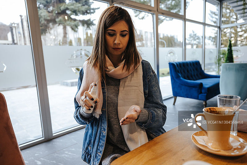 年轻女人在餐厅给手消毒图片素材