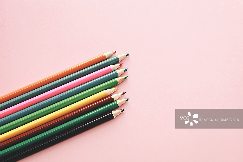 粉色背景上的彩色铅笔简约办公或学校背景，带复制空间图片素材