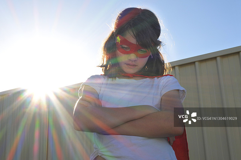 悲伤的超级英雄女孩交叉双臂向下看图片素材