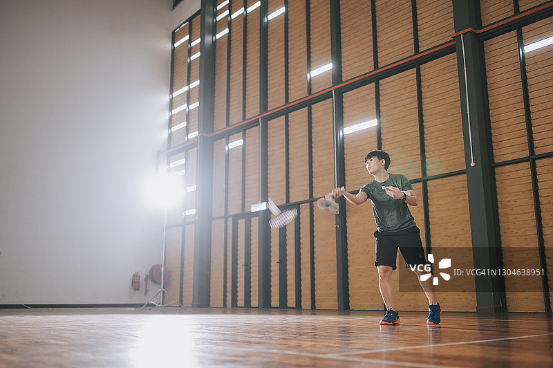 亚洲羽毛球女教练在羽毛球场指导学生图片素材