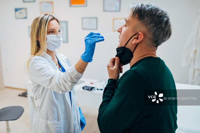 在医务室为病人做咽拭子PCR检测的专注女医生图片素材