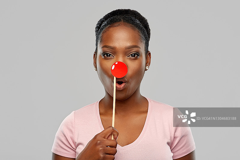 惊讶的非洲裔女人，带着红色的小丑鼻子图片素材