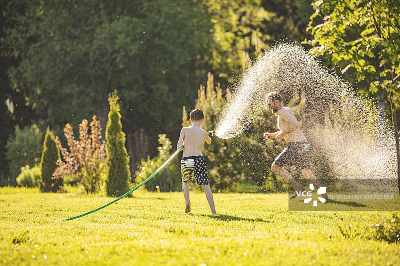 父子在后院玩水图片素材
