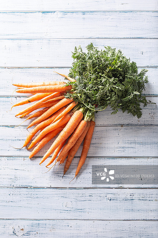 木桌上的一束新鲜胡萝卜（俯视图）图片素材
