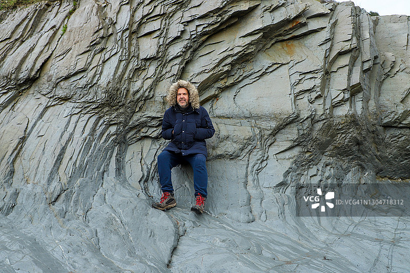 中年男子倚靠在石墙上图片素材