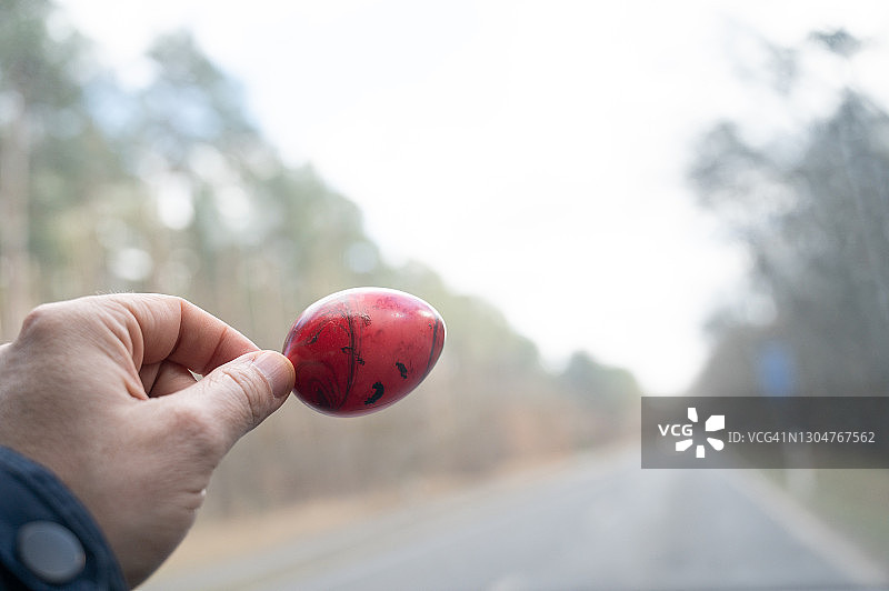 手持彩色复活节彩蛋，背景是德国的道路图片素材