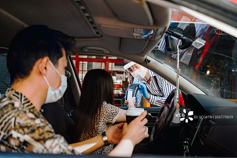 年轻女司机从咖啡店接过打包咖啡图片素材