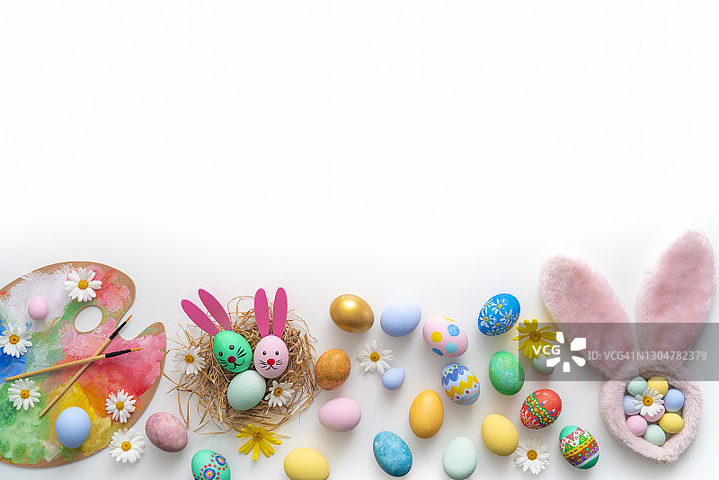 手绘兔子脸、耳朵和雏菊花的复活节彩蛋图片素材