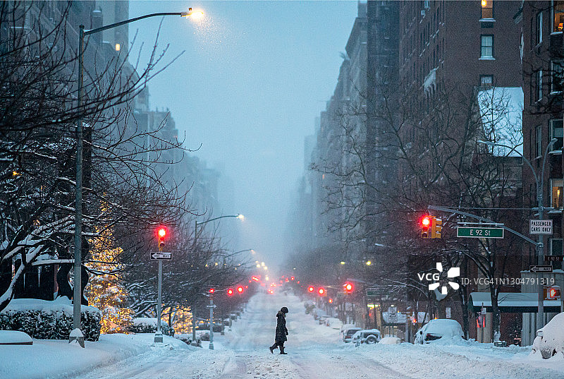 女人在下雪的纽约市过马路图片素材