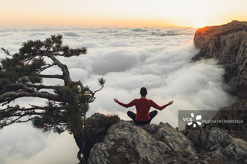 男人在山中独自冥想，欣赏壮丽的日出云海图片素材