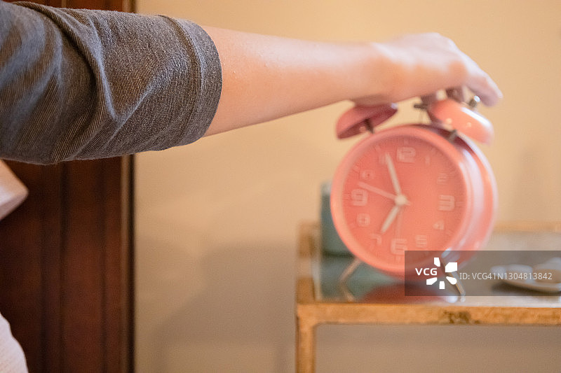 混血年轻女子起床关掉闹钟图片素材