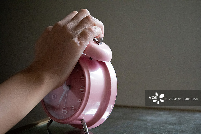 混血年轻女子起床关掉闹钟图片素材