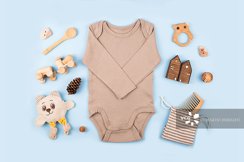 新生儿服装、木制玩具和蓝色背景上的配件图片素材