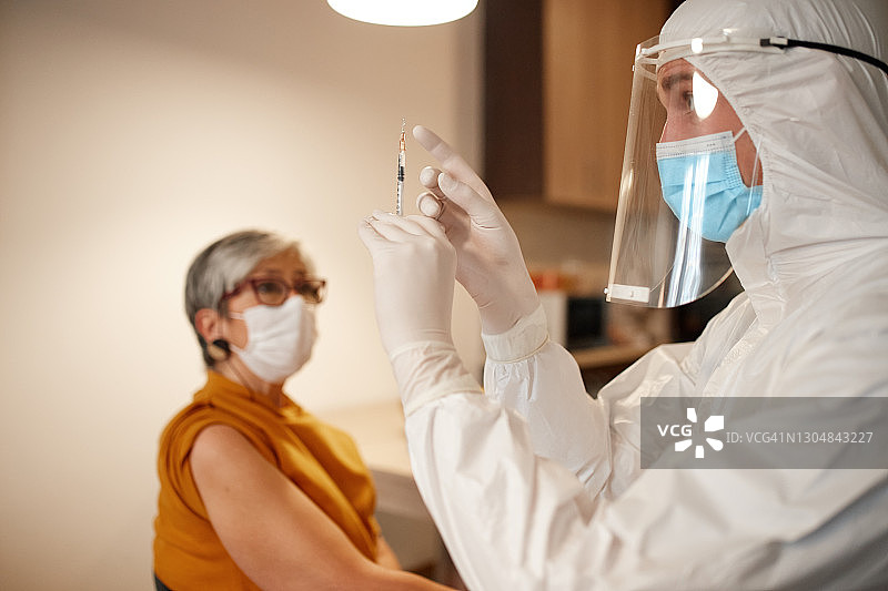 医生在家为老年妇女接种疫苗图片素材
