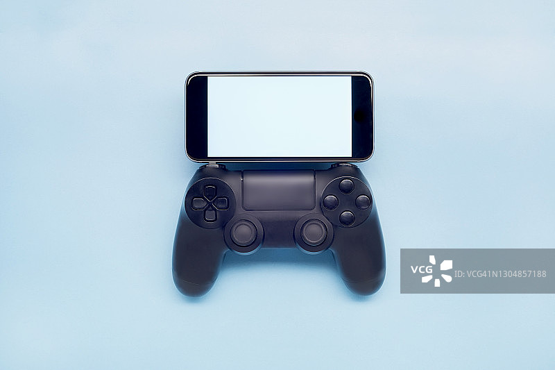 蓝色背景上的游戏控制器和发光显示的俯视照片图片素材