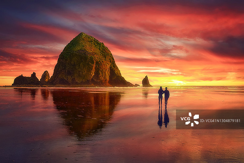 日落时分，壮观的云层笼罩着干草堆岩——俄勒冈州坎农海滩（美国）图片素材