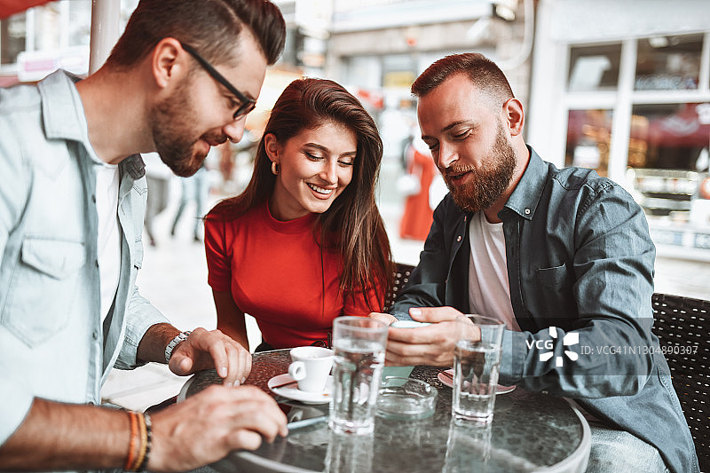 朋友们在咖啡时间用照片叙旧图片素材