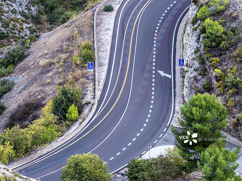 黄昏时分在弯曲的山路上行驶的汽车和卡车灯光图片素材
