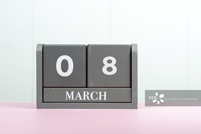 3月8日日历日期，灰色木制日历上的题字，粉红色桌子在白色背景上，国际妇女节图片素材