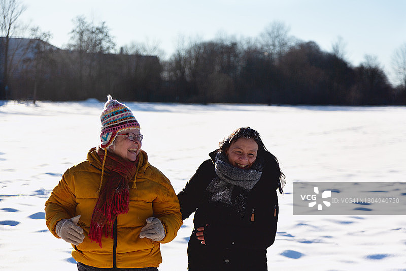 在雪地里快乐相伴的老年妇女图片素材