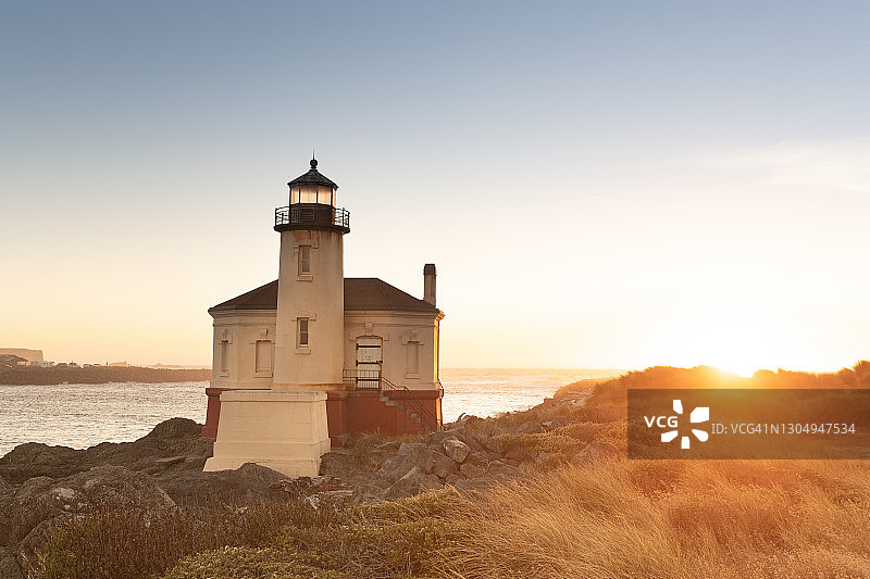 俄勒冈布拉德斯海滩州立公园日落时的科奎尔河灯塔图片素材