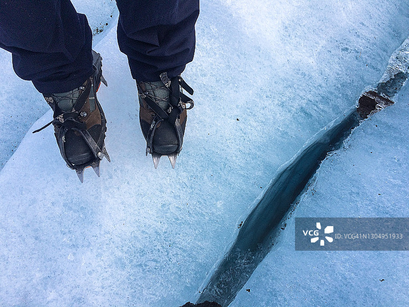穿着带冰爪的登山靴站在冰川上的人图片素材
