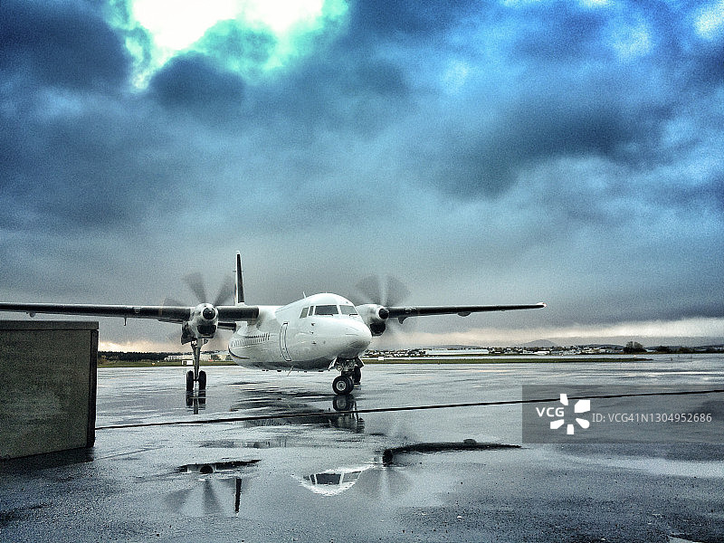 暴风雨天空下的双引擎涡轮螺旋桨飞机图片素材