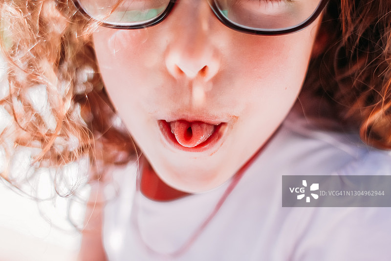 女孩卷起舌头，像一个U形字母图片素材