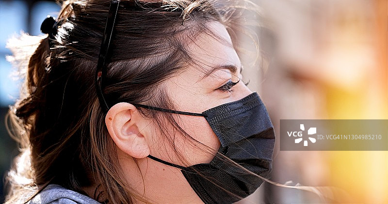 中年沉思的妇女戴着防护口罩图片素材