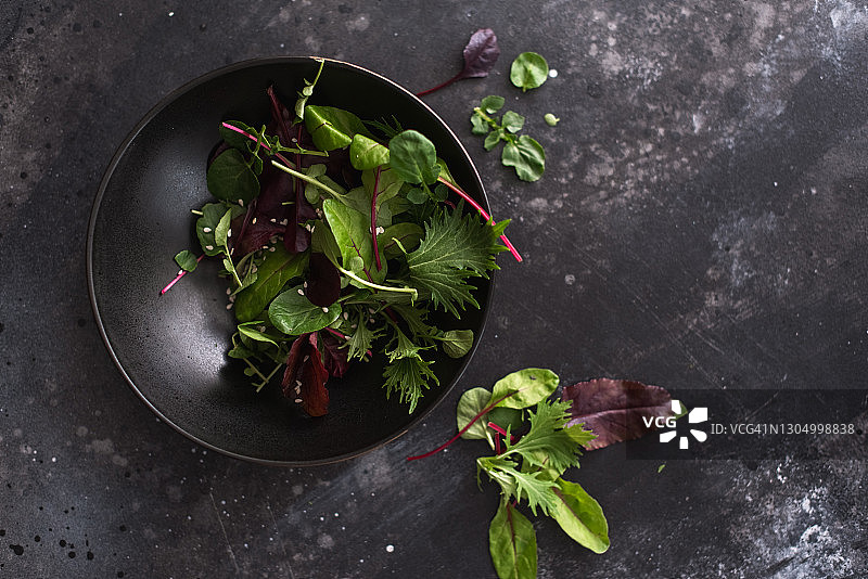 深色石板背景上用于沙拉的混合新鲜蔬菜叶图片素材