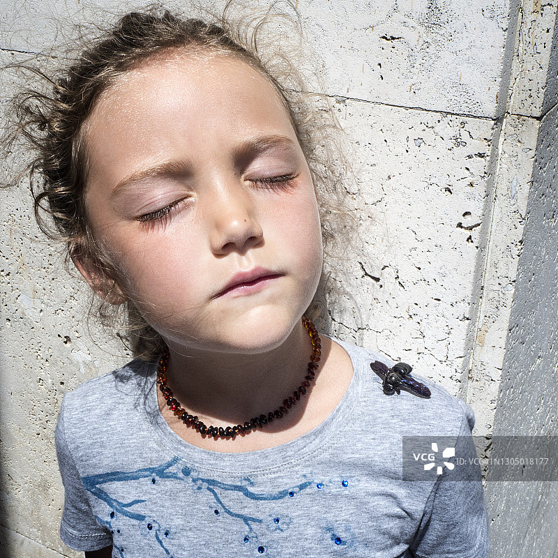 女孩站在阳光下，肩膀上停着一只昆虫图片素材