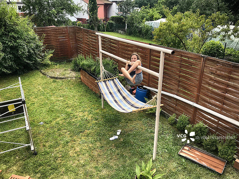 在波兰花园里，女孩在吊床上玩耍图片素材