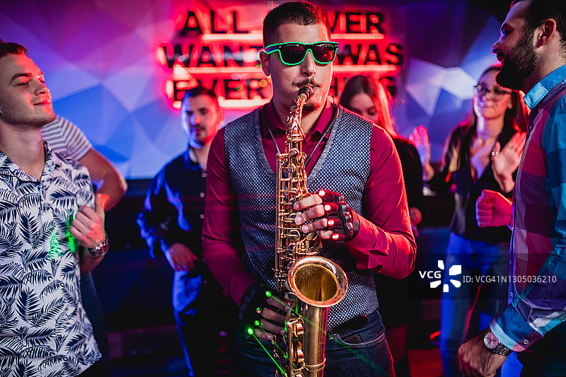 俱乐部派对上的萨克斯管演奏者图片素材