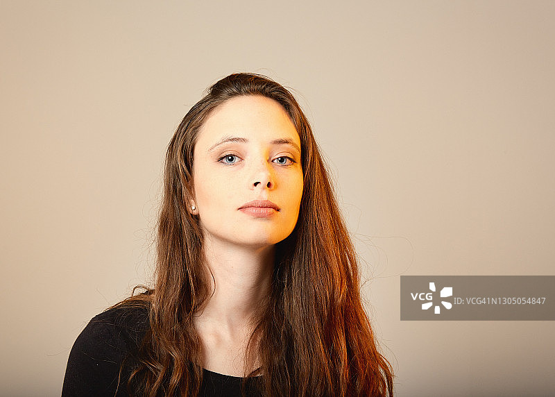 在昏暗灯光下表情忧郁的年轻女子图片素材