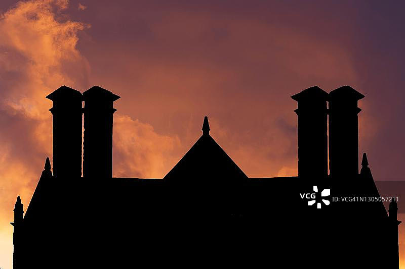 英国剑桥郡，英国庄园住宅在晚霞映衬下的烟囱轮廓图片素材