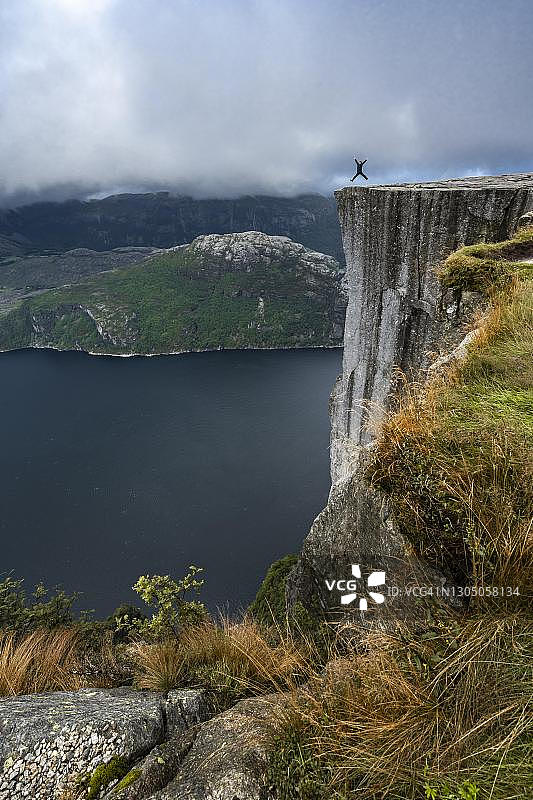在挪威吕瑟峡湾的布道岩跳跃的人图片素材