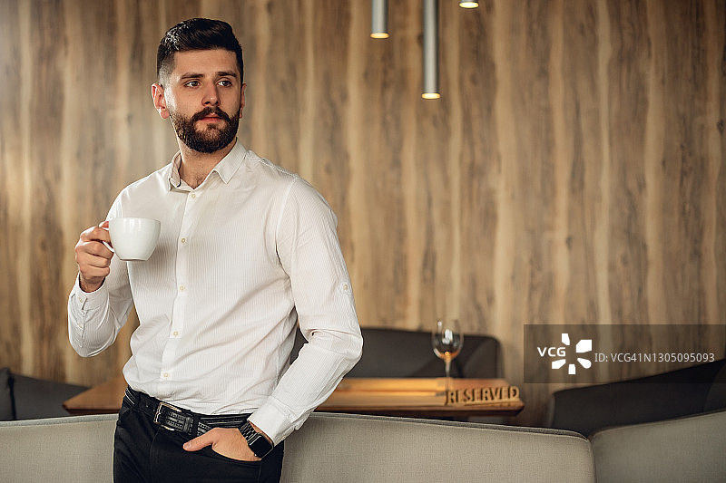 咖啡馆内富有魅力的成年络腮胡男人，生活方式概念照片，有复制空间，附带一杯饮料、咖啡或茶图片素材