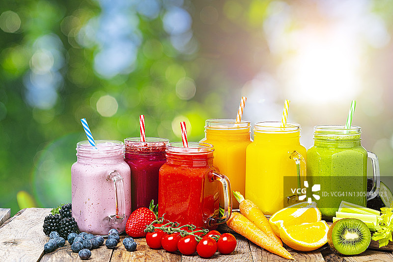 户外木桌上的健康彩虹蔬果冰沙图片素材