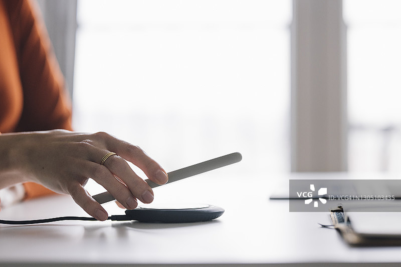 商界女性：在家办公时使用手机的匿名年轻女商人图片素材