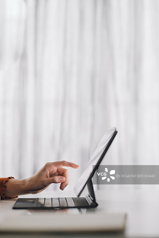 职场女性：一位匿名的年轻白人女商人，在家工作时使用数字平板电脑图片素材