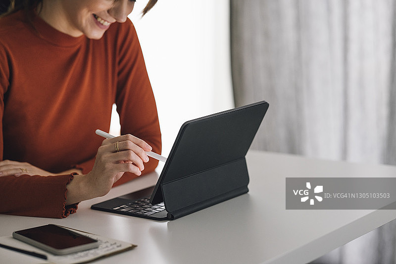 居家办公的年轻白人女商人使用平板电脑图片素材