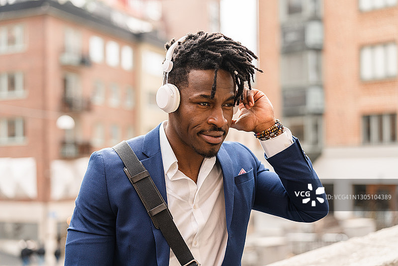 商人戴无线耳机收听播客图片素材