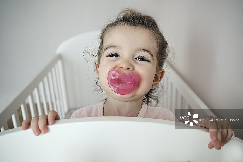 在婴儿床里的两岁女孩图片素材