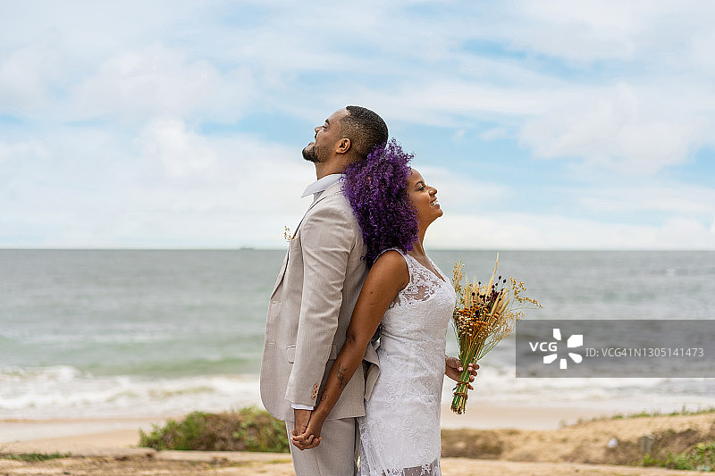 幸福的年轻夫妇背靠着彼此图片素材