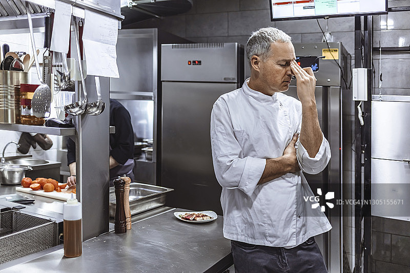 工业厨房里焦虑的厨师图片素材