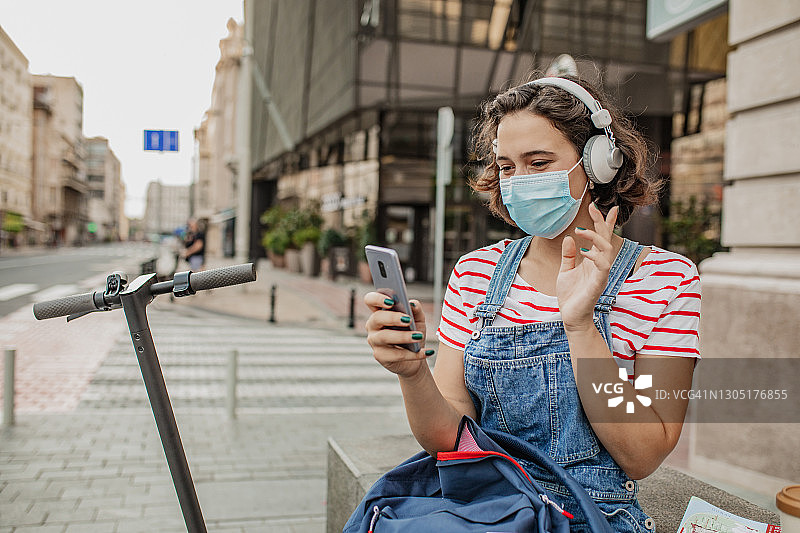 戴口罩的女游客用手机进行视频通话图片素材